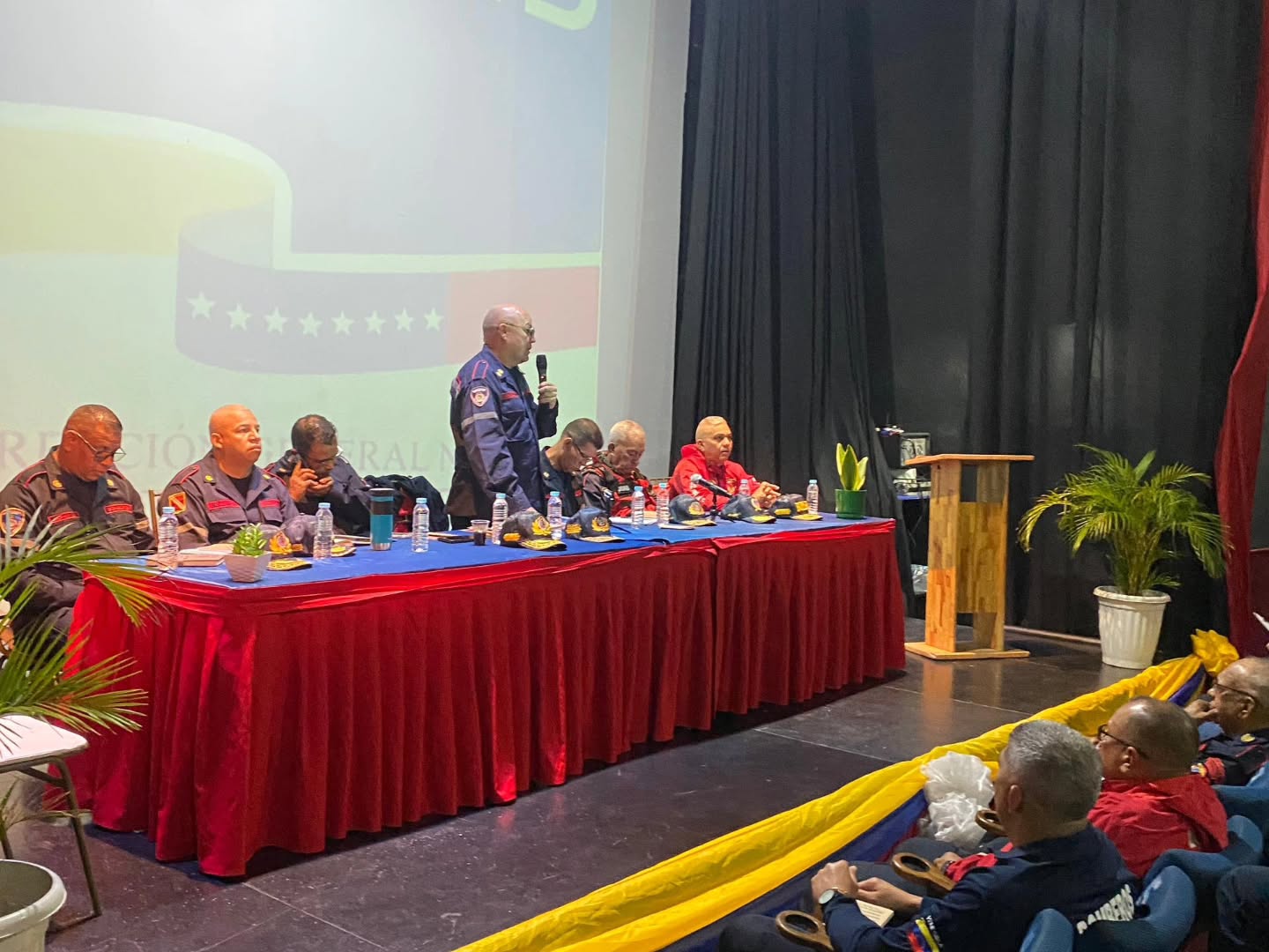 Primer General Juan Carlos González Lidera Encuentro Estratégico con la REDAN Central para el Fortalecimiento Jurídico y Operativo.
En un ambiente de alta cohesión institucional y compromiso profesional, el Primer General (B) Juan Carlos González Director General Nacional de Bomberos y Presidente del FONBE, encabezó el Primer Encuentro de Primeros y Primeras Comandantes de la REDAN Central y la REDAN Capital. La jornada, que tuvo como epicentro el imponente Teatro Guacara Plaza, se consolidó como un espacio fundamental para el crecimiento del pie de fuerza bomberil.
Uno de los pilares centrales de este encuentro fue la socialización de la Ley Orgánica del Servicio de Bomberos y de los Cuerpos de Bomberos y Bomberas y Administración de Emergencias de Carácter Civil, así como el análisis profundo de la Constitución de la República.
Bajo la dirección del Primer General, los comandantes debatieron sobre el entramado legal que rige su actuación, garantizando que cada procedimiento esté plenamente respaldado por la normativa vigente.
El evento trascendió la formalidad para convertirse en un debate dinámico y enriquecedor, donde los líderes regionales intercambiaron experiencias sobre las leyes que fortalecen su operatividad y la protección de sus funcionarios.
"No solo se trata de la operatividad en el campo, sino de la solidez de nuestros fundamentos legales. Este debate que hemos generado hoy nos permite salir más fortalecidos y conscientes de nuestra responsabilidad constitucional", destacó el Primer General González ante el cuerpo de comandantes.
Con la realización de este encuentro en el municipio Guacara, la REDAN Central y capital dan un paso firme hacia la modernización y profesionalización, demostrando que la formación teórica y el debate de ideas son herramientas tan vitales como el equipo de rescate para salvaguardar al pueblo venezolano.
#DireccionGeneralNacionalDeBomberos #Guacara